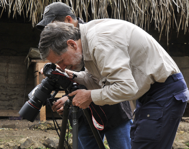 Nicholas  photographing flora and fauna in tropical rain forest in native house with a Canon EOs 1Ds Mark III plus a EF 180mm telephoto-macro lens, Sayaxche Petén Guatemala December 2010